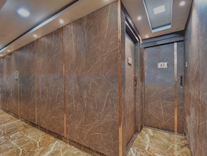 Un couloir aux murs de marbre et une porte portant l’inscription « A3 ».