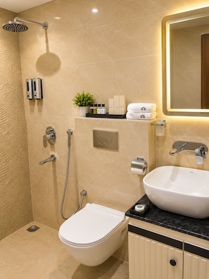 Un bagno moderno con doccia, servizi igienici, lavandino e uno specchio.