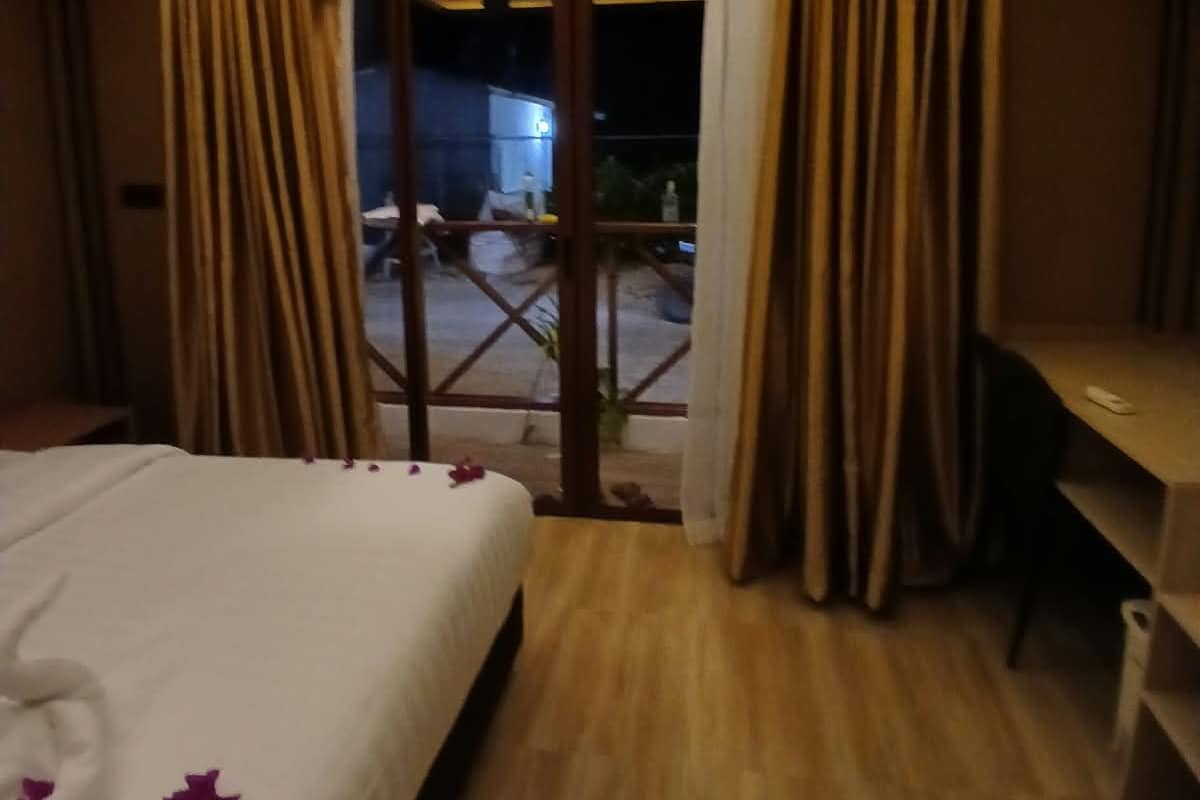 Ein Hotelzimmer mit Bett, Schreibtisch und Blick ins Freie.