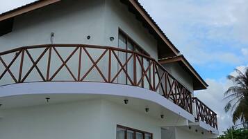 A two-story building with a balcony and a covered porch area.