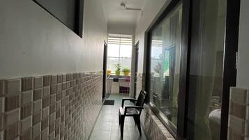 A corridor with a bench, a sliding glass door, and a view of the outside.