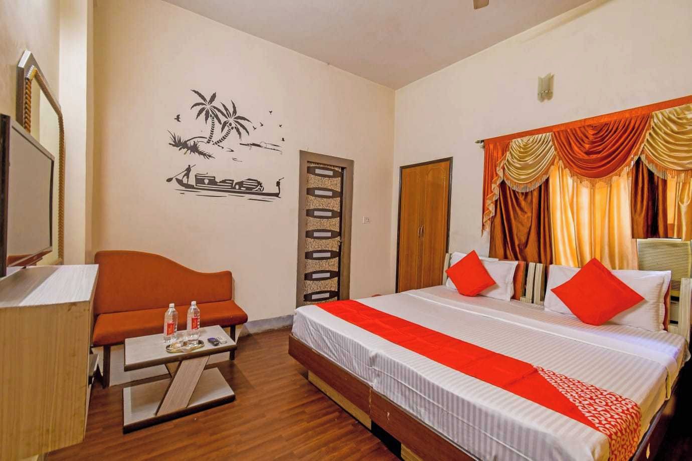 Una habitación de hotel con cama, escritorio, silla y un adorno en la pared.
