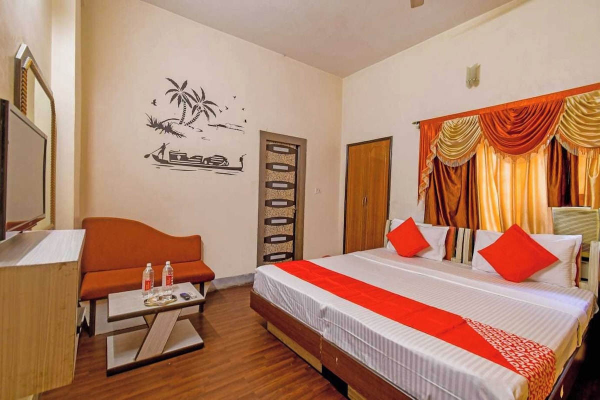 A hotel room with a bed, a desk, a chair, and a wall decoration.