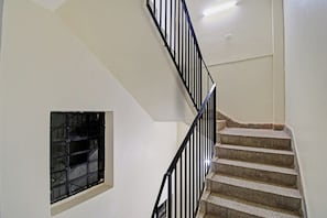 A staircase with black railings and beige steps leading to a landing. - Collection O Green Leaf Near Acropolis (Kolkata)