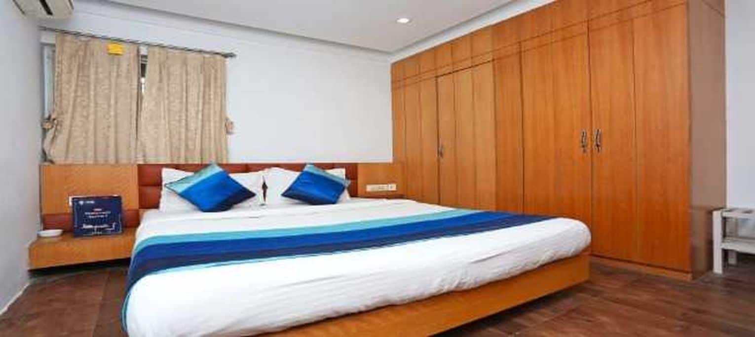 Ein Hotelzimmer mit einem großen Bett, einem Holzschrank und einem Nachttisch.