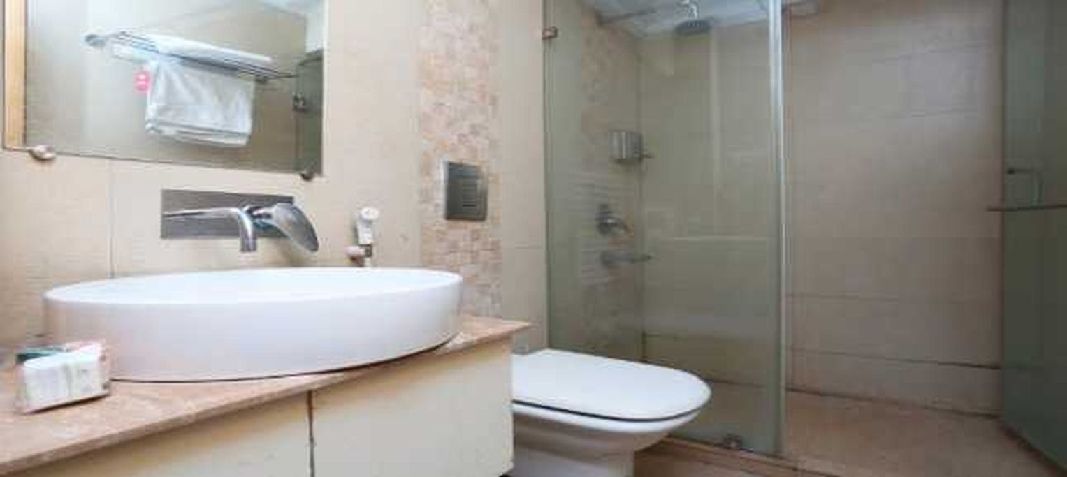 Un baño con un lavamanos blanco, un inodoro y una cabina de ducha de vidrio.
