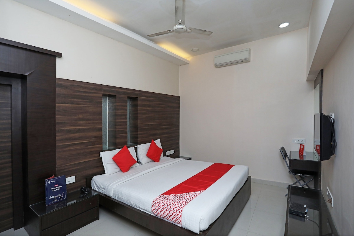 A hotel room with a bed, bedside table, nightstand, and a television.