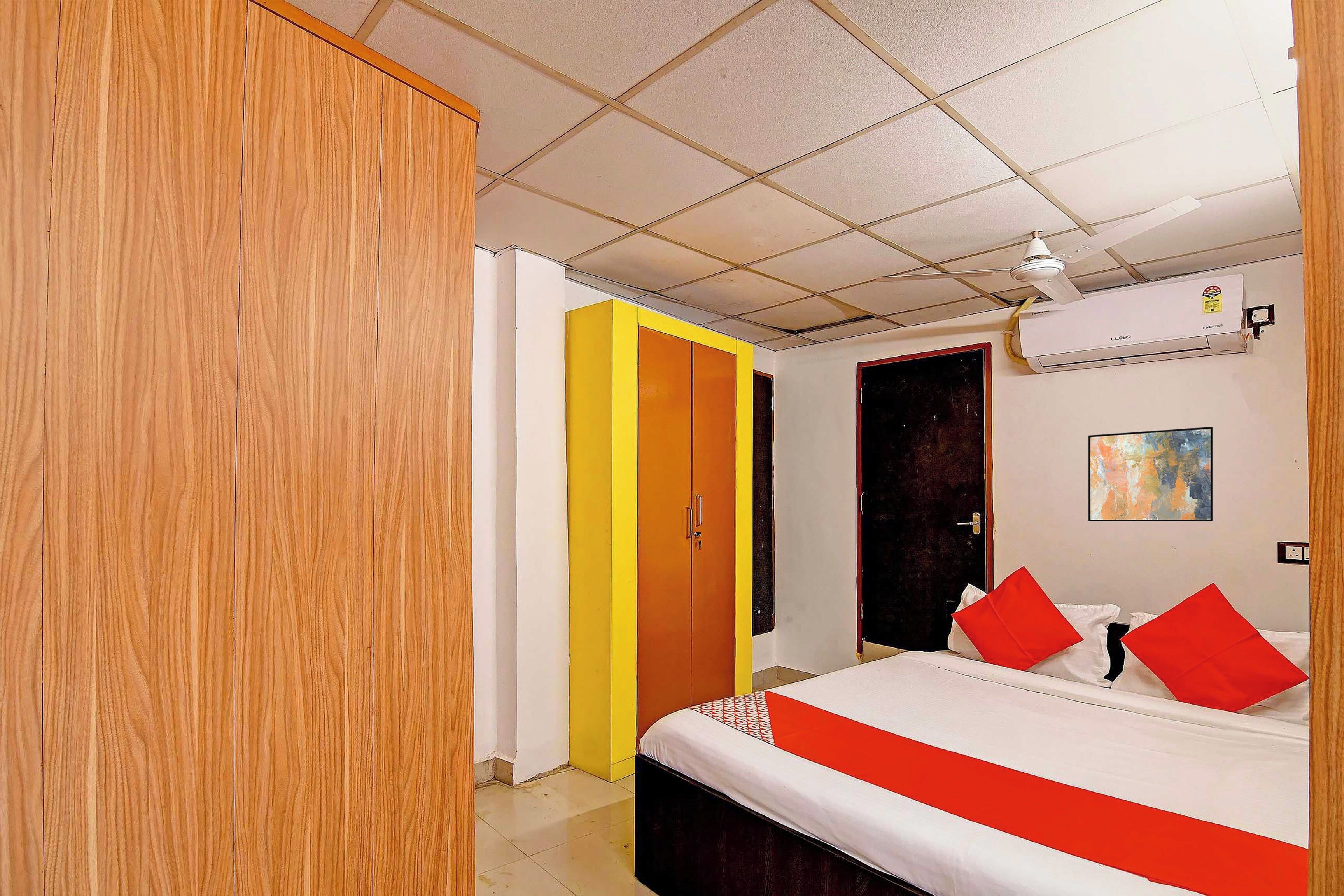 Una habitación de hotel con una cama, un armario, una puerta y un equipo de aire acondicionado.