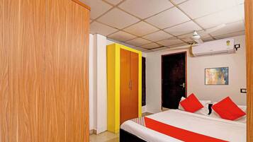 Una habitación de hotel con una cama, un armario, una puerta y un equipo de aire acondicionado.