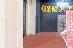 A corridor leading to a gym area with a sign that reads 'GYM X TYO'. - Hotel O Jalan Regency (Kolkata)