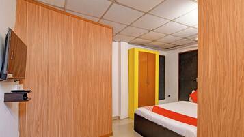 A hotel room with a bed, a desk with a computer, and a wardrobe.