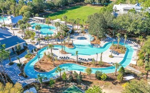 A resort with multiple swimming pools, sun loungers, and palm trees. - WaterColor | 2 King Suites, Beach & Pools (Santa Rosa Beach)
