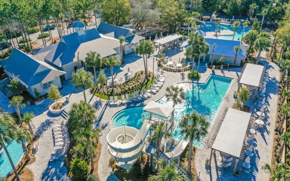 Ein Resort mit mehreren Schwimmbecken, Liegebereichen und Palmen.