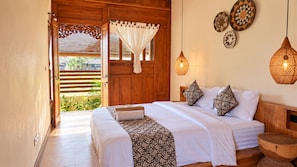 Quarto com porta de madeira, cama com roupa de cama estampada e objetos decorativos nas paredes.