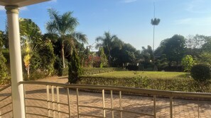 A paved pathway with a metal railing, surrounded by lush greenery and a clear sky. - 10mins away from the Entebbe International Airport  it’s a one bedroom (Entebbe)