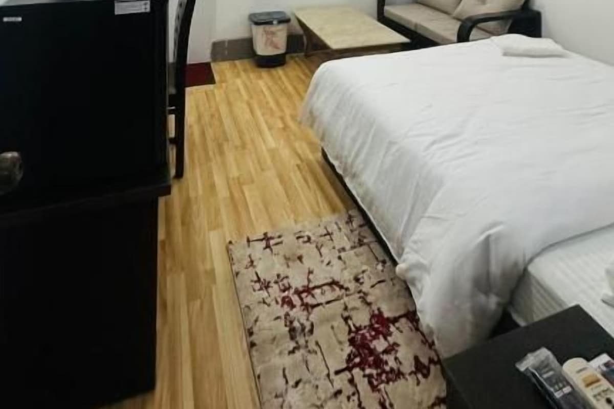 Una camera da letto con un letto, una scrivania, una sedia, una ventola a soffitto e un condizionatore d'aria.