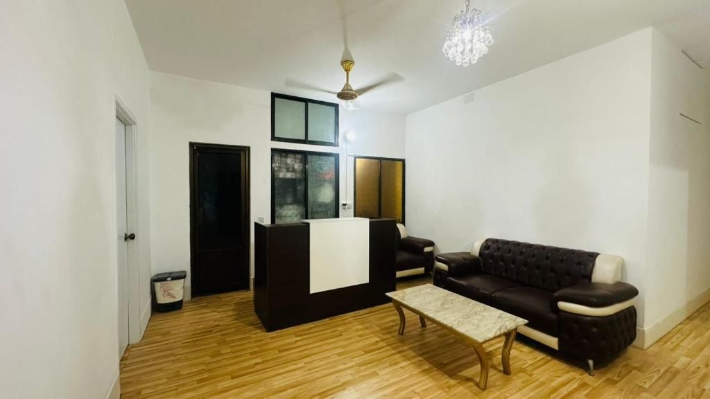 Una sala de estar con sofá, una mesa de centro, un mueble para televisión y un ventilador de techo.