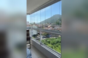 A balcony with a view of a residential area and a mountain. - New Listing (Ubatuba)