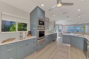 A modern kitchen with a central island, built-in appliances, and a view of the outdoors. - Sarasota Sunset Villa-Luxury waterfront pool home (Sarasota)