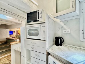 A kitchen with a built-in microwave, oven, and a coffee maker on the countertop. - Villa Sweet Nest with private heatable pool (Kassiopi)
