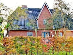 A two-story brick house with a steeply pitched roof, a visible chimney, and a blue door. - Holiday Apartment in Wrixum With Terrace (Wrixum)