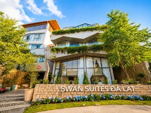 Entrada de un hotel con un cartel que dice 'SWAN SUITES DA LAT'.