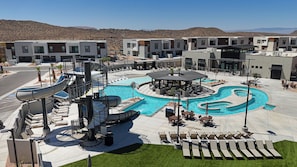 A modern hotel with a pool area, including a water slide and lounge chairs. - The Desert Isle: Private Hot Tub + Family Games (Washington)