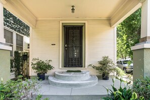 A house with a front porch, a black metal gate, and potted plants. - Walk to Shops & Restaurants! Classic Nola Home (New Orleans)