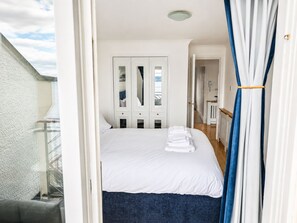 A hotel room with a bed, a bathroom, and a view of the outside. - Forth Bridge View | Private Balcony | Waterfront | Near Edinburgh | Near Airport (Dalgety Bay)