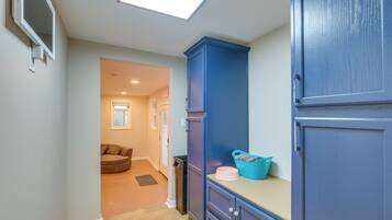 A hallway with a skylight, a blue cabinet, and a door leading to another room.