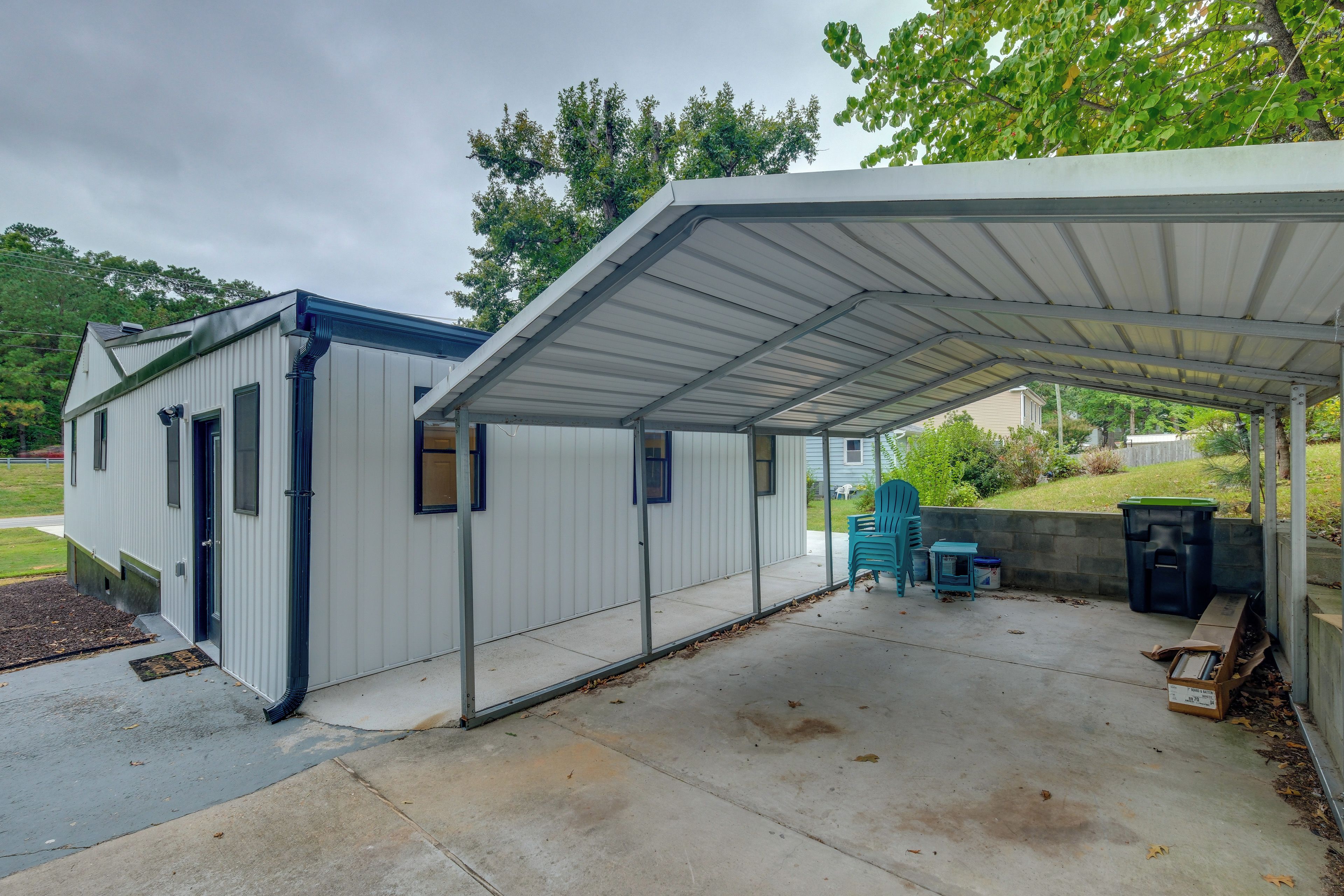 A covered outdoor area with a metal roof, a small shed, and a concrete patio.