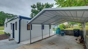A covered outdoor area with a metal roof, a small shed, and a concrete patio.