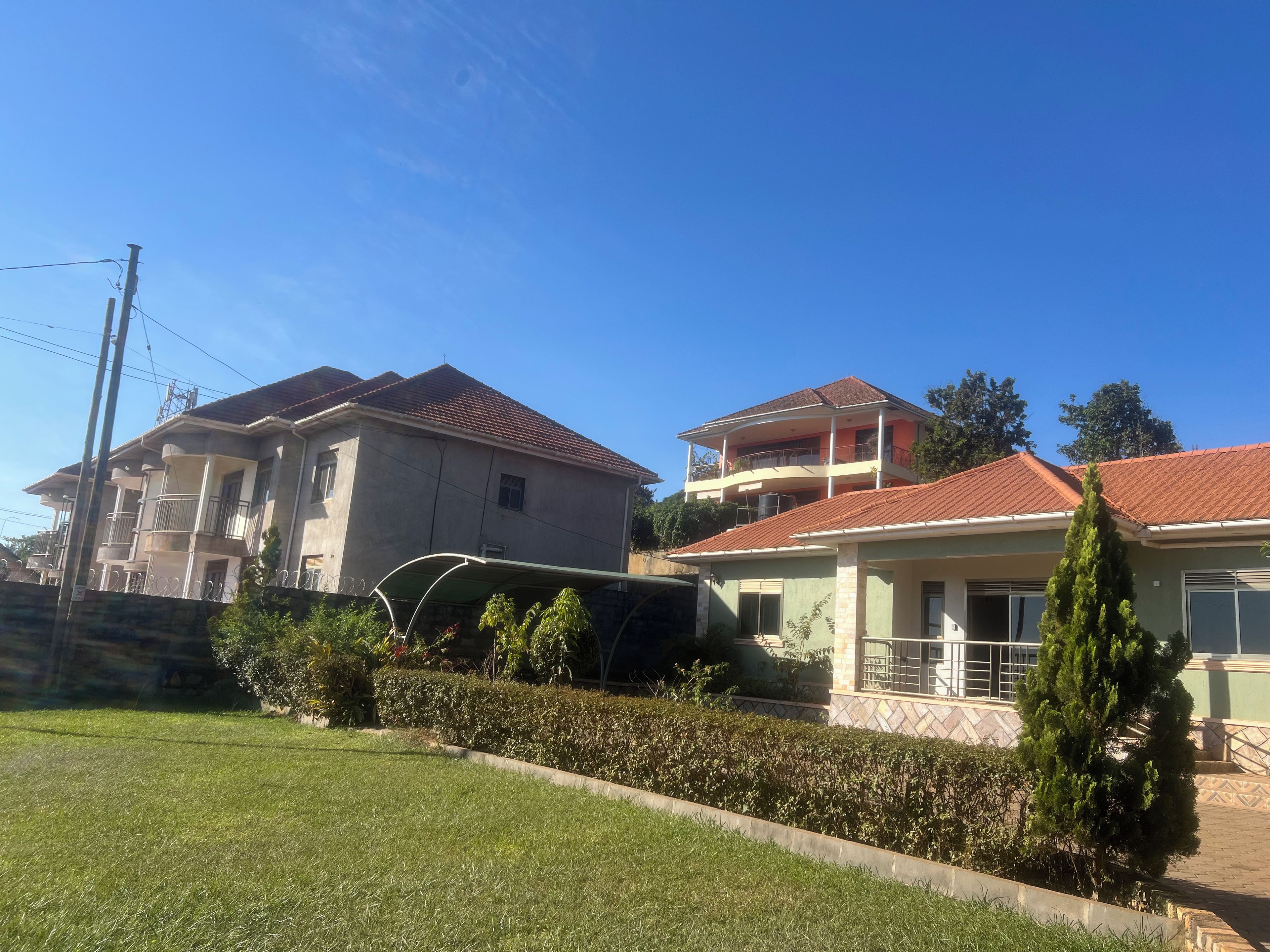Un quartier résidentiel avec des maisons à deux étages, une pelouse bien entretenue et un ciel d’un bleu éclatant.