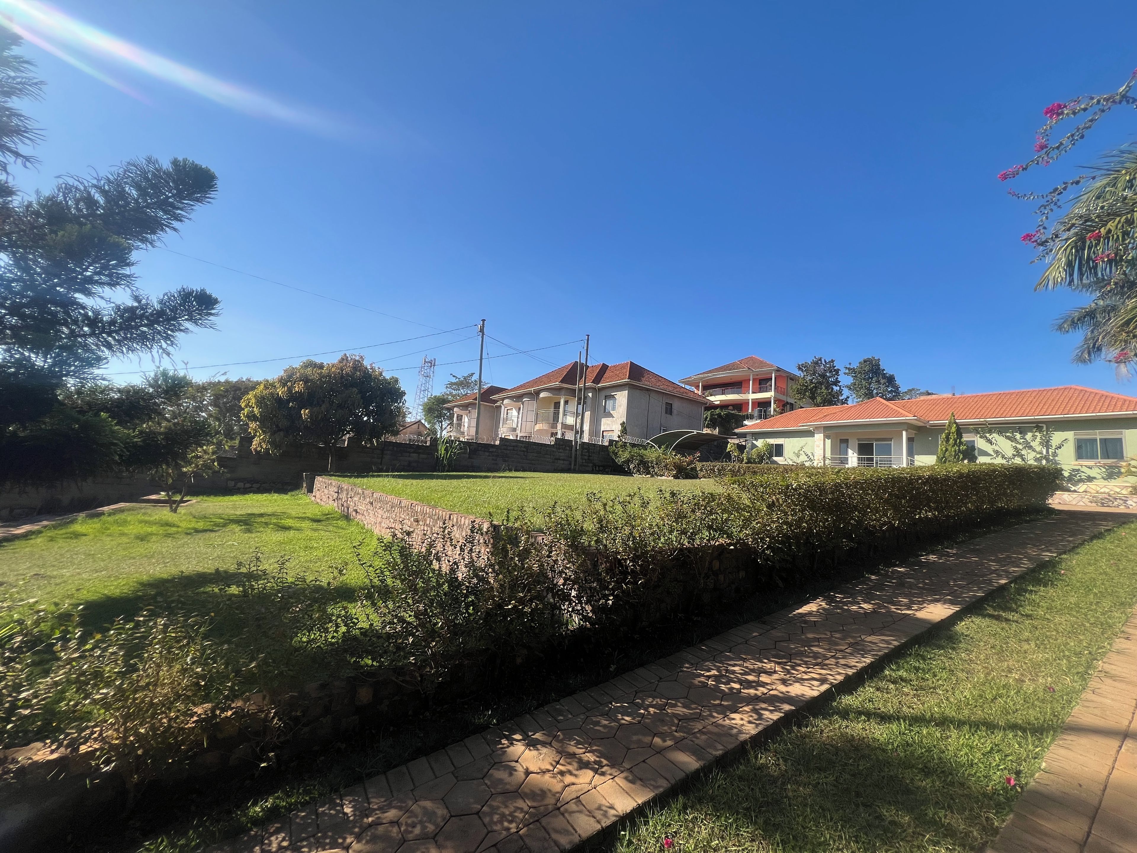 Un quartier résidentiel avec des maisons, un mur en pierre et une pelouse verdoyante.