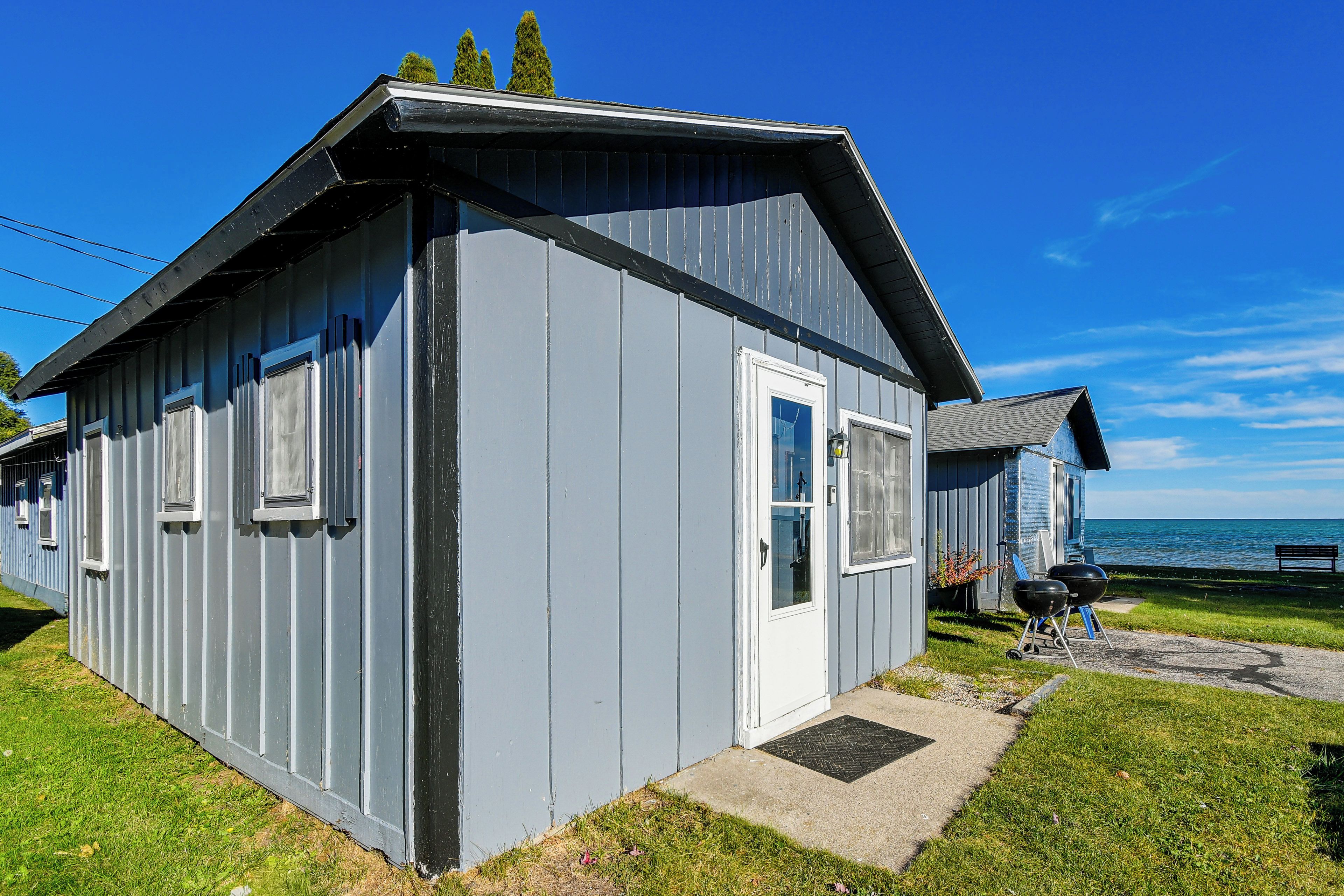 A small, single-story building with a sloped roof, a door, and windows.