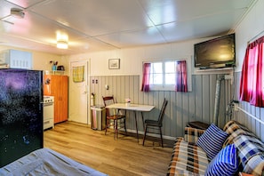 A compact living space with a kitchenette, a dining area, and a seating area with a sofa and chairs. - Quaint Couples Unit w/ Lake Access in Tawas City (Tawas City)