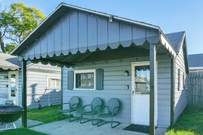 A small, single-story house with a porch, a door, and a window. - Quaint Couples Unit w/ Lake Access in Tawas City (Tawas City)