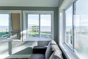 A room with a view of the sea, a window with a view of a dock, and a built-in air conditioning unit. - Yard w/ Lake Views! Quaint Tawas City Escape (Tawas City)