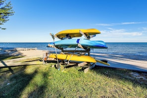 A stack of kayaks on a wooden stand by the beach. - Yard w/ Lake Views! Quaint Tawas City Escape (Tawas City)