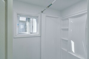 Ein Zimmer mit Fenster, Tür und einer weißen Wand.