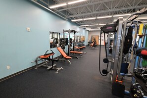 A gym with weightlifting equipment, benches, and mirrors. - Cape Canaveral Getaway w/ Pool - Walk to Beach (Cape Canaveral)