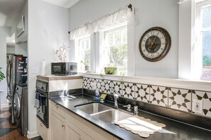 A kitchen with a double sink, a microwave, and a refrigerator. - Jastro Park-facing 1922 Condo in Bakersfield (Bakersfield)