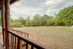 A wooden deck with a view of a grassy yard and trees. - Norfork Lake Cabin, 2 Mi to the Water (Calico Rock)