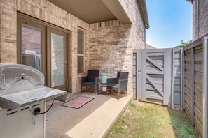 A patio area with a table and chairs, a door, and a gate. - Yard, Patio, Office! Spacious Home in Union Park (Aubrey)