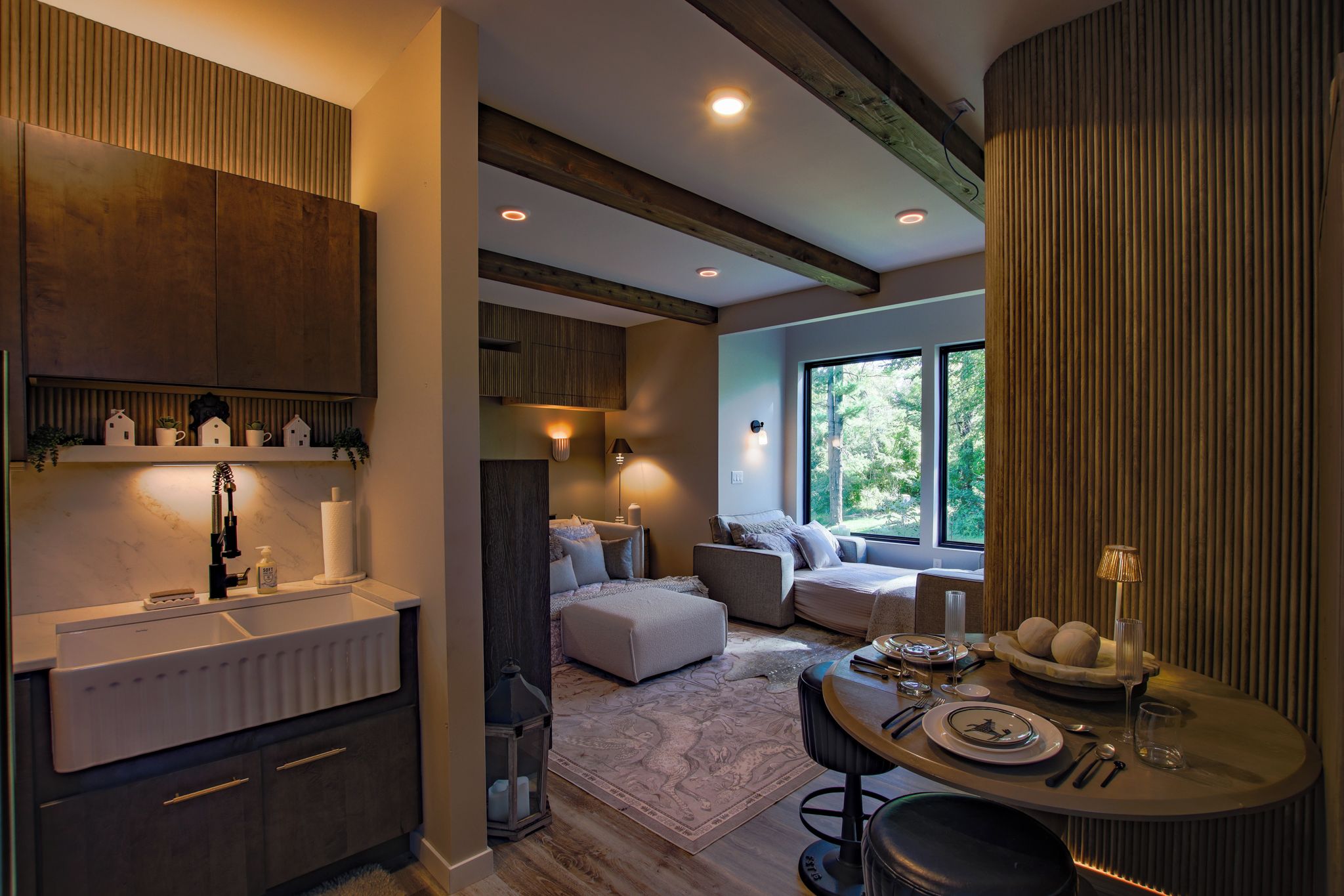 A modern interior with a kitchen, dining area, and seating space with large windows.
