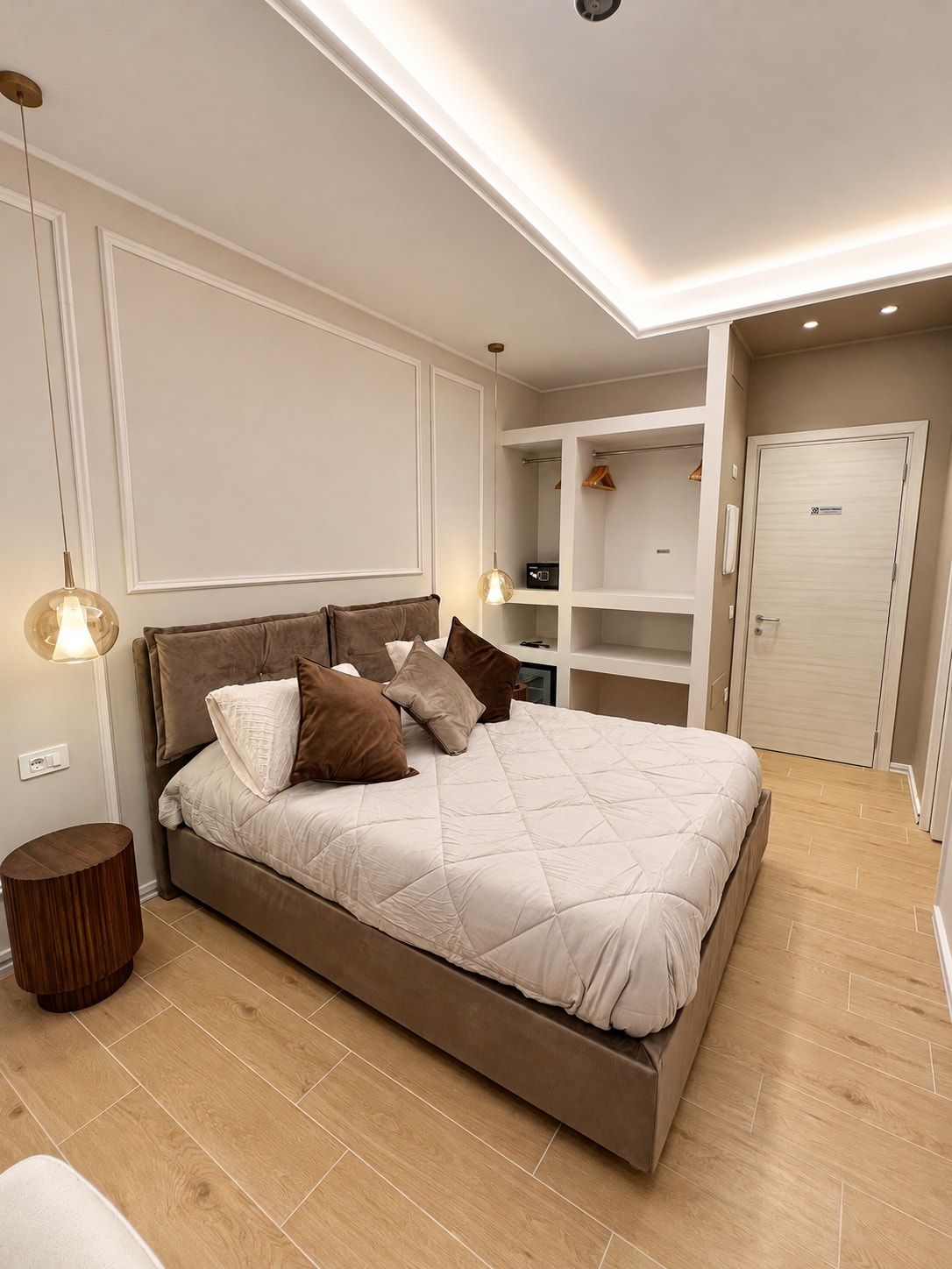 Ein modernes Schlafzimmer mit einem großen Bett, Einbauschränken und einem begehbaren Kleiderschrank.