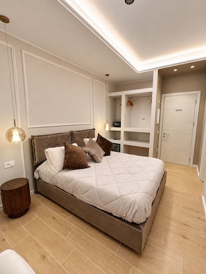 Een moderne slaapkamer met een groot bed, inbouwkasten en een inloopkast.