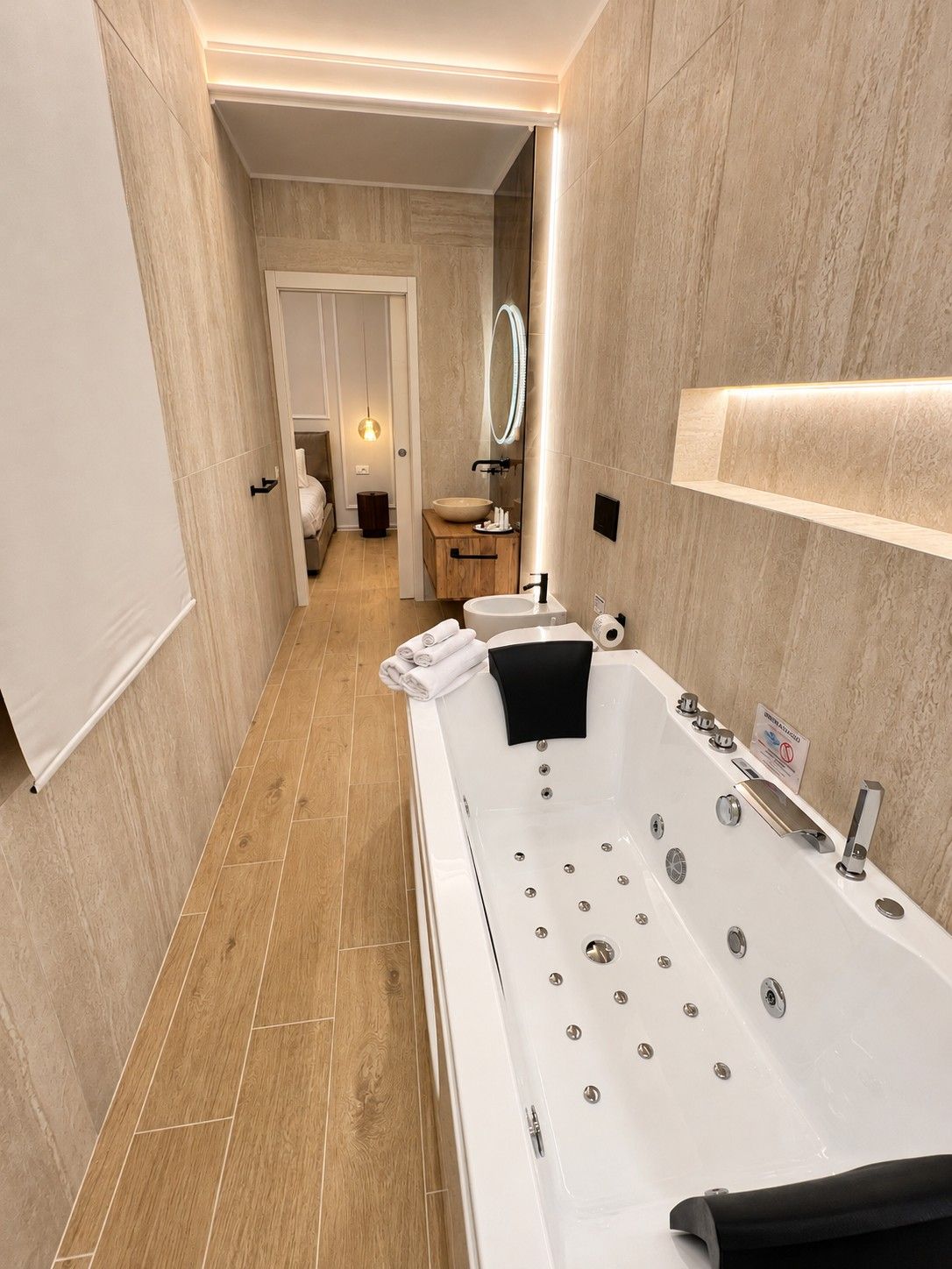 Un baño moderno con una bañera grande, un tocador con espejo y un armario de madera.