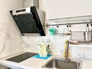 Cuina amb microones integrat, búl, rentaplat i campana extractora d'acer inoxidable.