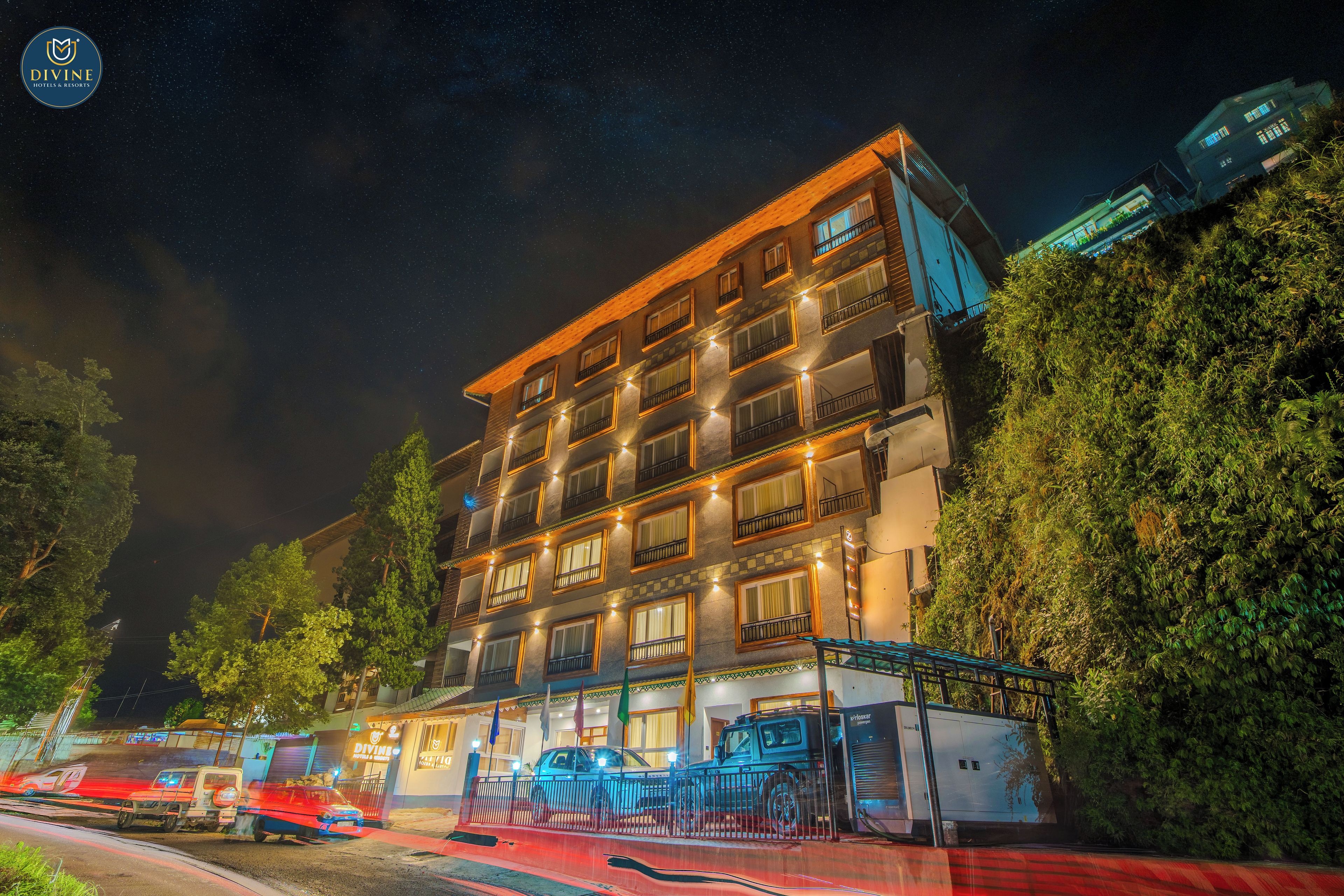 A multi-story hotel with balconies and a parking area.